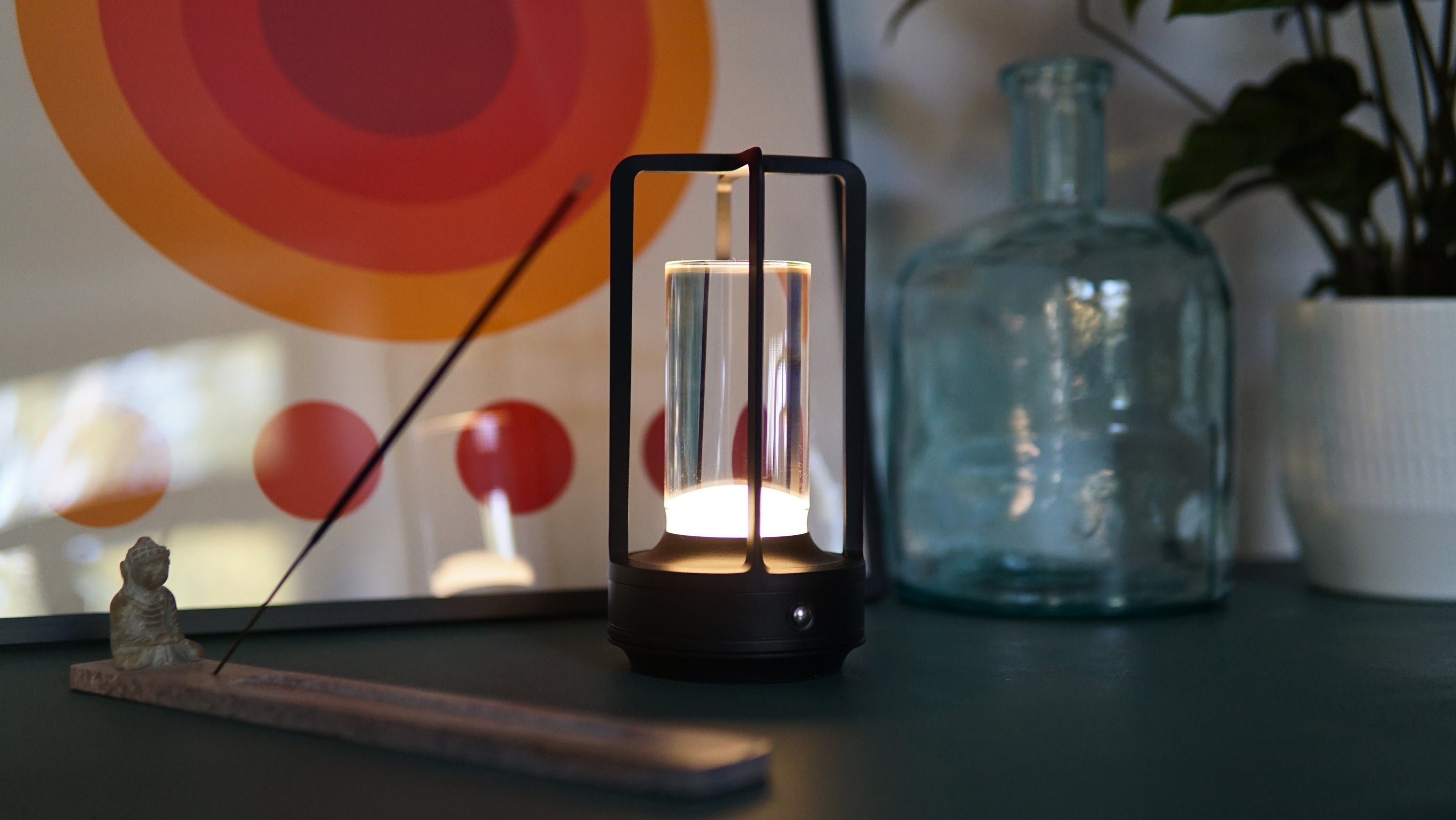 Das Ambient Light auf einem Nachttisch, daneben ein Räucherstäbchen und ein Notizbuch – stimmungsvolle Lichtquelle für ruhige Morgenrituale.