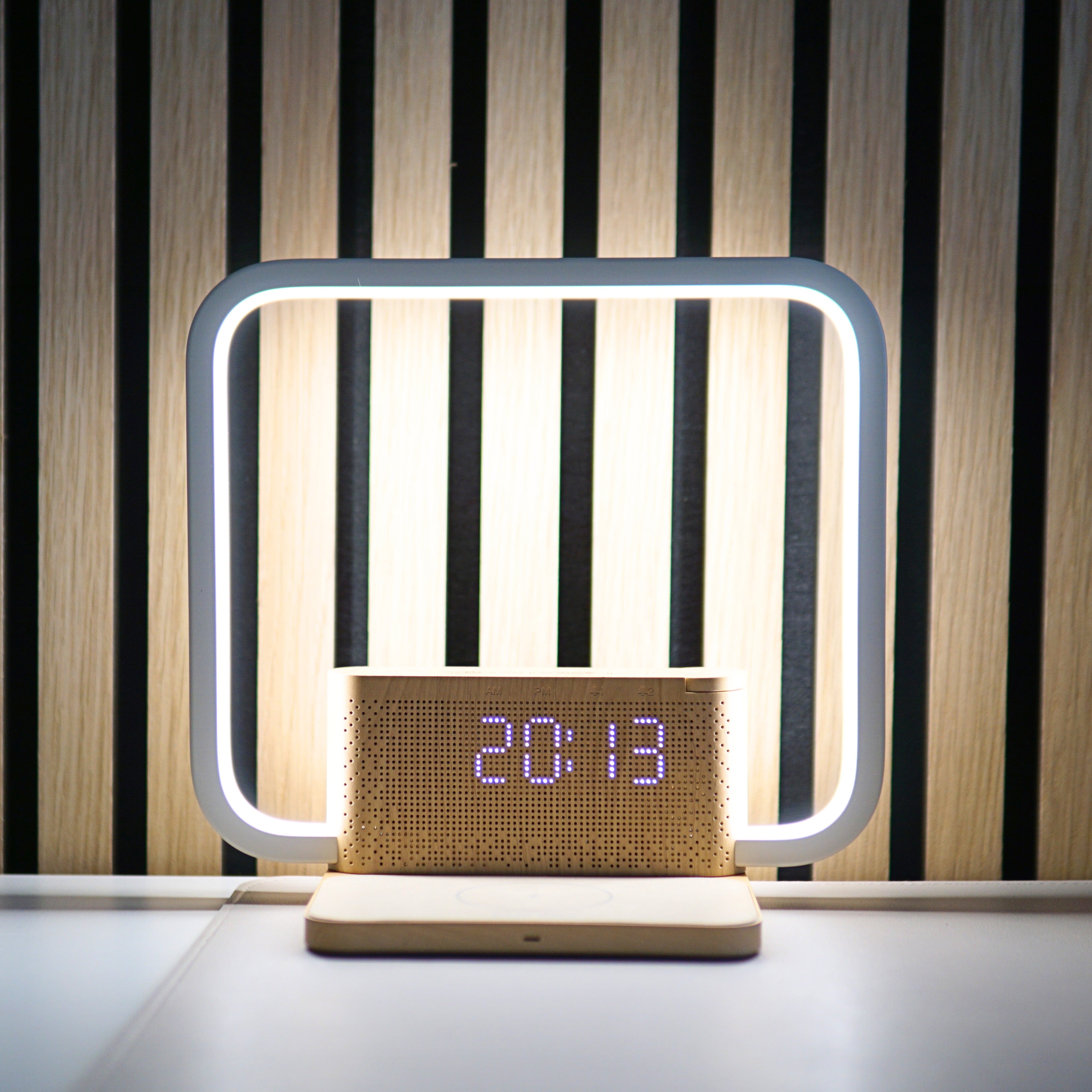 Rise & Charge Lichtwecker auf einem Schreibtisch am Abend – stimmungsvolle Nachttischlampe mit kabellosem Laden und Touch-Dimmer