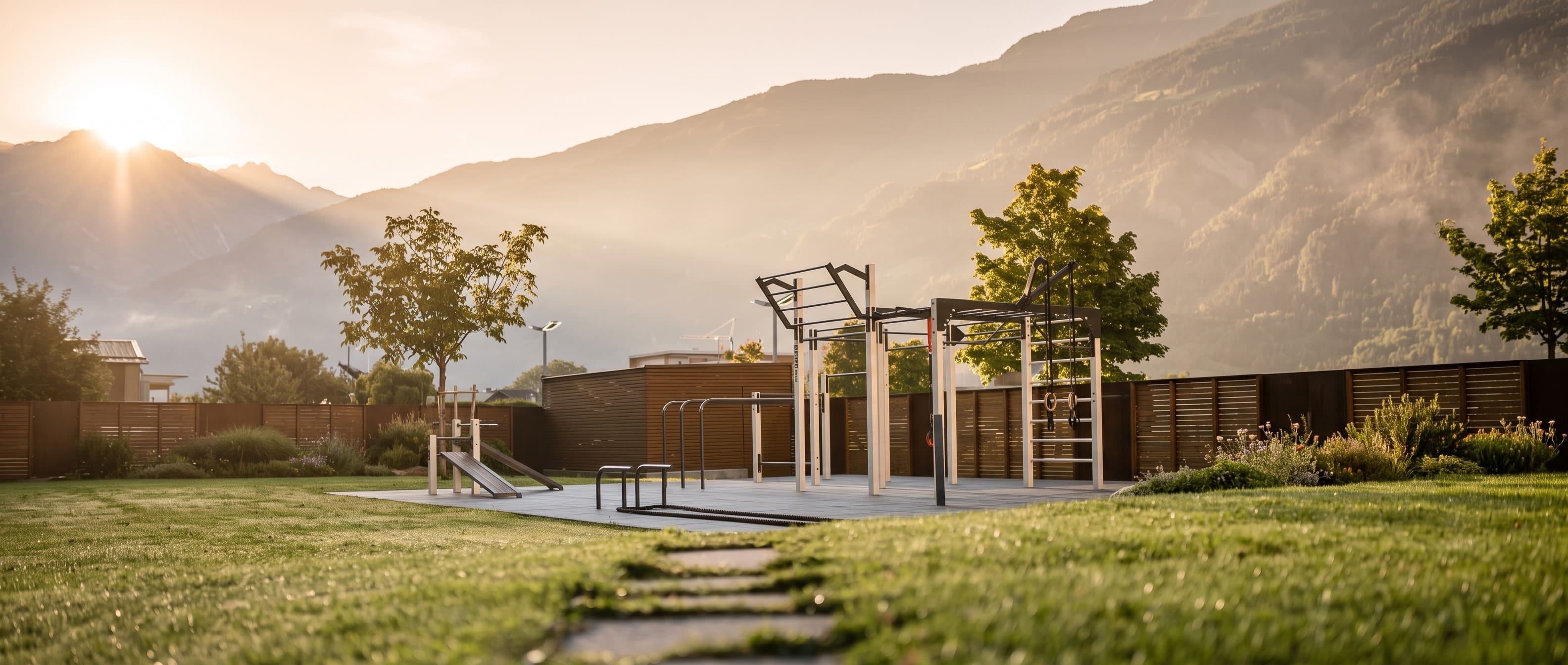 Früher Sommermorgen auf einem Outdoor-Sportplatz mit Klimmzugstangen vor Naturkulisse, warmes Morgenlicht, Sinnbild für eine aktive Morgenroutine ohne Smartphone